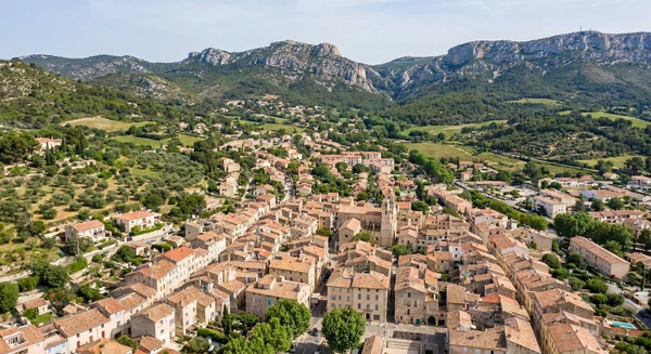 Vue aérienne ou panoramique d'Aubagne montrant la commune avec ses caractéristiques urbaines et le paysage provençal environnant, montagnes et espaces verts en arrière-plan. Image claire, professionnelle, représentant le cadre géographique de cette ville des Bouches-du-Rhône. Photographie réaliste sans texte, logo ou filigrane visible.