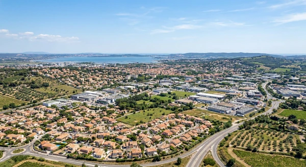 Vue aérienne ou panoramique de Marignane montrant la commune depuis une perspective élevée avec ses caractéristiques urbaines provençales : zones résidentielles, bâtiments, espaces verts et paysage environnant typique des Bouches-du-Rhône. Image claire, professionnelle et réaliste représentant le cadre géographique de cette commune. Sans texte, logo ou filigrane visible.
